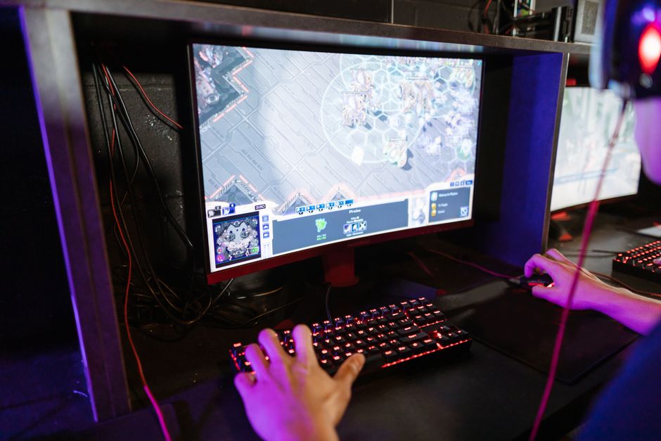 Jogador participando de uma partida de estratégia em um ambiente de eSports com vários monitores e iluminação especial.