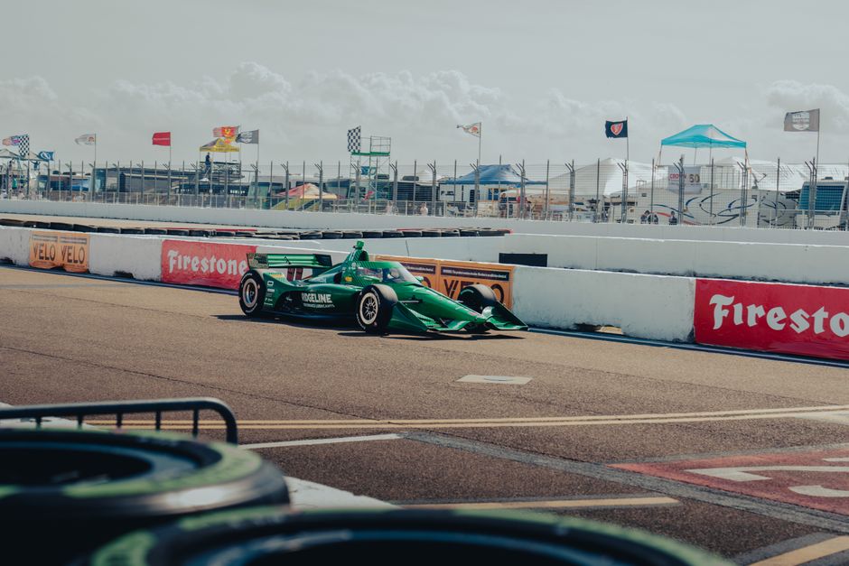 Carro de corrida verde em pista de circuito automobilístico, pronto para uma corrida de endurance ou Fórmula Indy.
