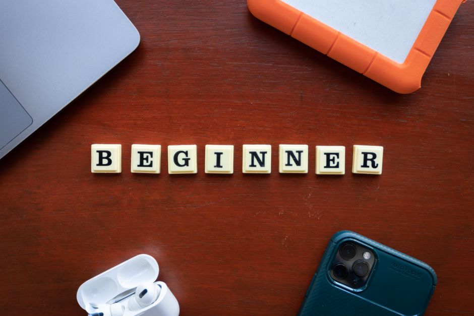 Imagem com blocos formando a palavra 'BEGINNER' sobre uma superfície de madeira, simbolizando o início de uma nova jornada ou aprendizado.