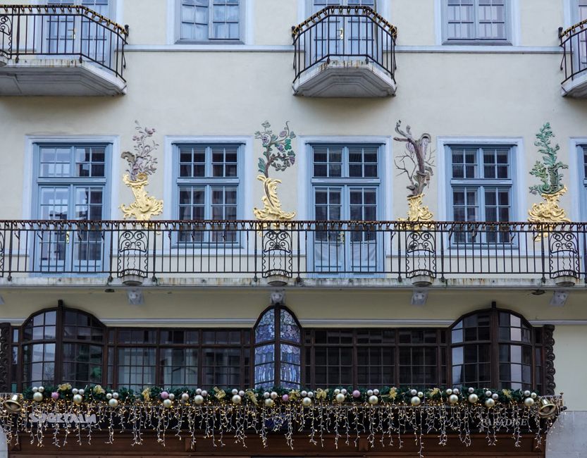 Fachada de prédio histórico decorado com enfeites natalinos, exalando charme e elegância em preparação para o fim de ano.