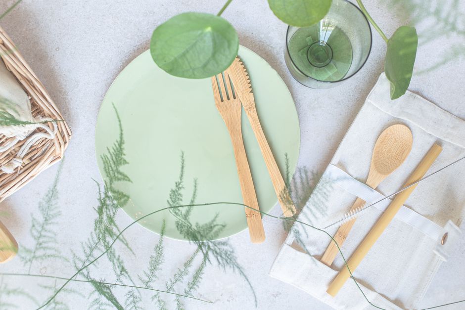 Imagem de uma mesa com utensílios de destaque para um tema de sustentabilidade e consumo consciente, com elementos naturais e utensílios ecológicos.