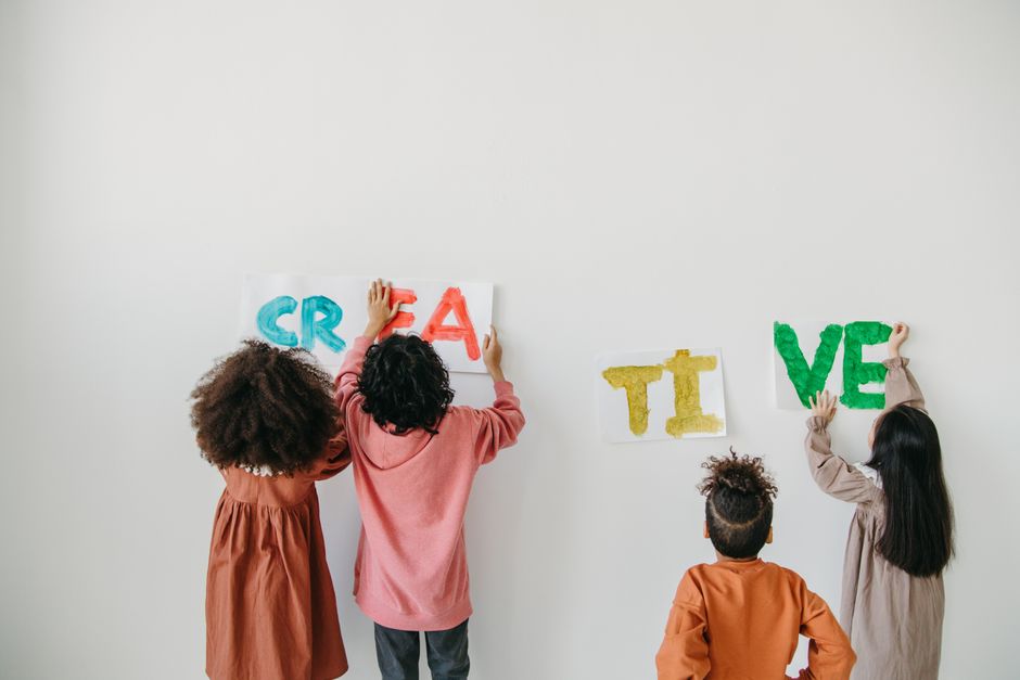 Crianças formando a palavra 'CRIE' na parede, simbolizando criatividade e inovação na educação infantil.
