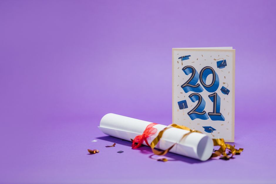 Imagem comemorativa de despedida de 2021 e boas-vindas a 2022 com uma placa, diploma e confetes sobre fundo roxo.