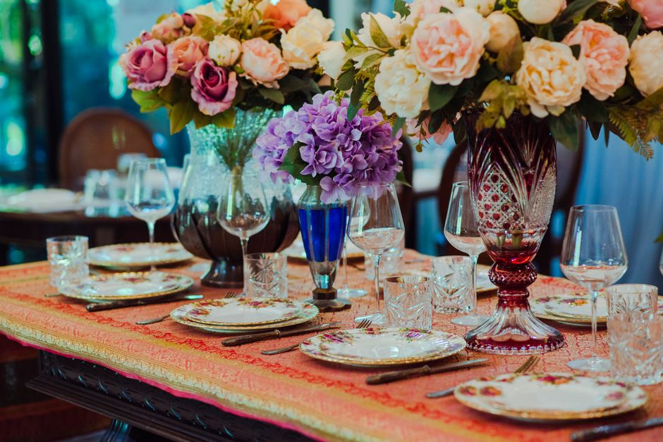 Mesa de jantar decorada com arranjos florais elegantes, ideal para eventos sofisticados ou celebrações especiais.
