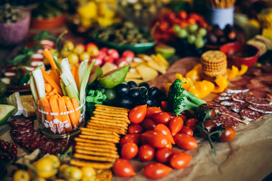 Mesa com uma variedade de alimentos saudáveis, destacando frutas, vegetais e frios, ideal para um tema de alimentação equilibrada ou buffet de refeições.