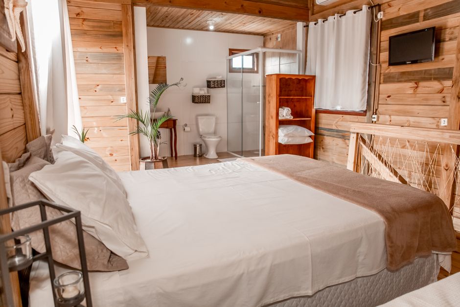 Quarto aconchegante com um toque rústico, destacando um ambiente confortável e bem decorado para hospedagem ou hospedagem de turistas.