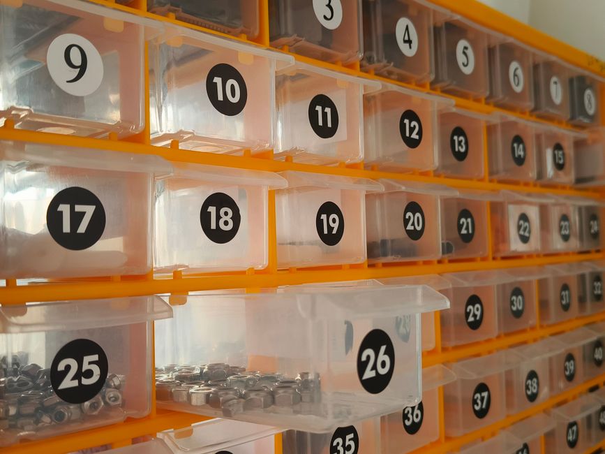 Imagem que mostra uma organização de pequenos componentes eletrônicos em compartimentos numerados, ideal para artigos sobre armazenamento de componentes ou eletrônica.