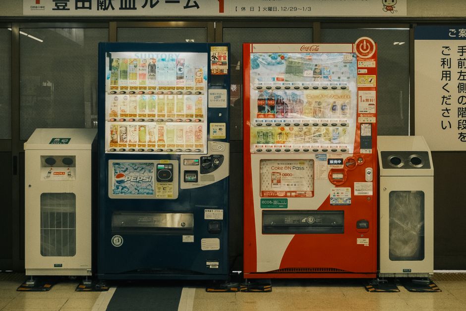Imagem de máquinas de venda automática de bebidas e snacks, comum em ambientes comerciais e de lazer no Japão.