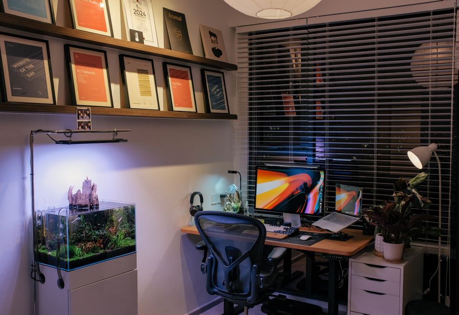 Espaço de trabalho organizado com computadores, livros de gestão e detalhes que refletem produtividade e criatividade em ambiente doméstico ou de escritório.
