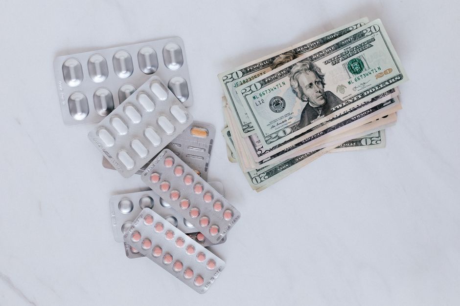 Imagem que relaciona saúde financeira com medicamentos e dinheiro.