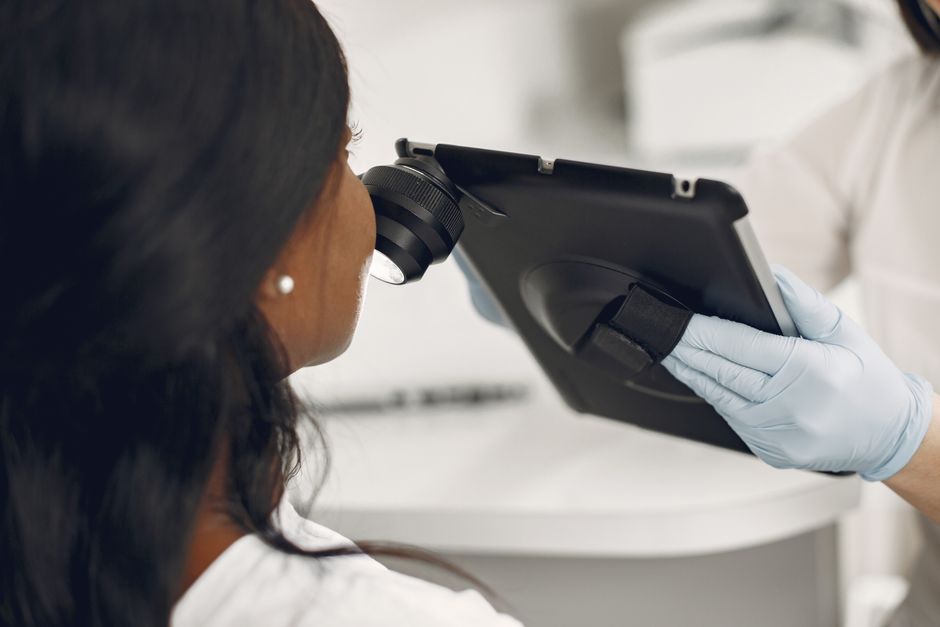 Profissional de saúde utilizando um equipamento de alta tecnologia para exame, simbolizando inovação médica.