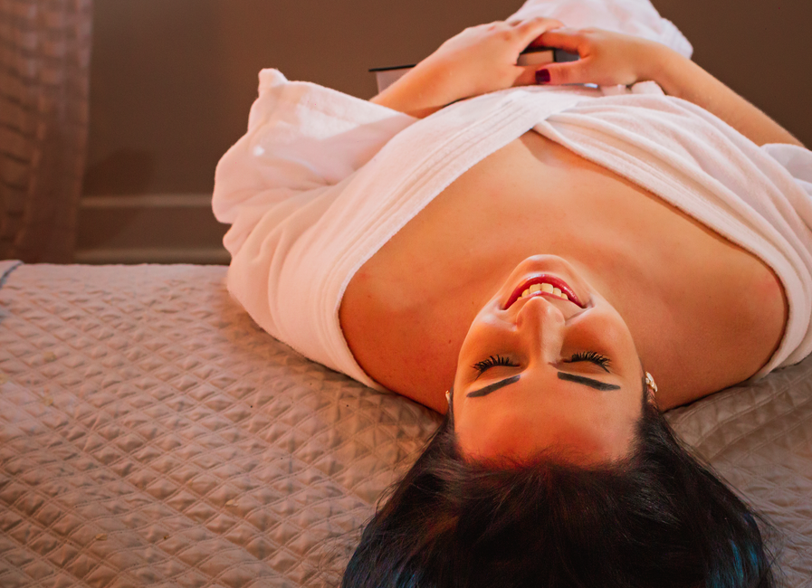 Mulher relaxando e sorrindo após uma pausa no spa, transmitindo bem-estar e cuidado pessoal.