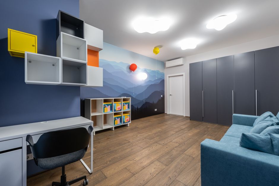 Ambiente de escritório moderna e bem decorado, ideal para trabalho criativo ou estudo, com móveis funcionais e parede com pintura de montanhas ao fundo.