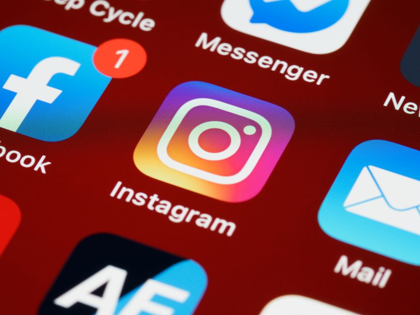 Tela de smartphone exibindo aplicativos de redes sociais, com destaque para o ícone do Instagram, simbolizando estratégias de marketing digital e presença online.
